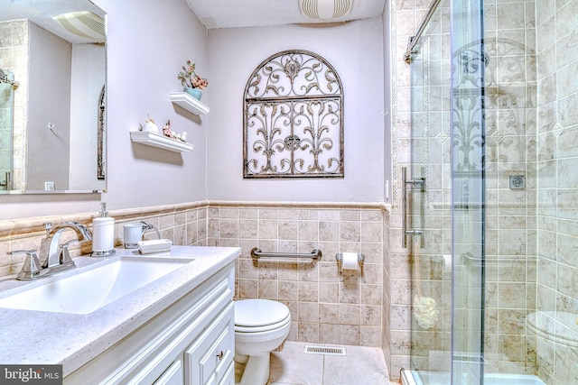 bathroom featuring tile walls, vanity, toilet, and an enclosed shower