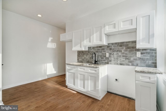 kitchen featuring white cabinetry, light hardwood / wood-style floors, and sink