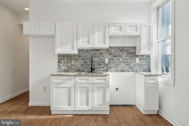 kitchen featuring white cabinetry, sink, and light hardwood / wood-style flooring