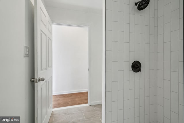 bathroom with tile patterned floors and a tile shower