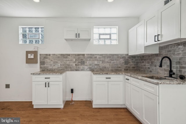 kitchen with light hardwood / wood-style flooring, sink, and white cabinets