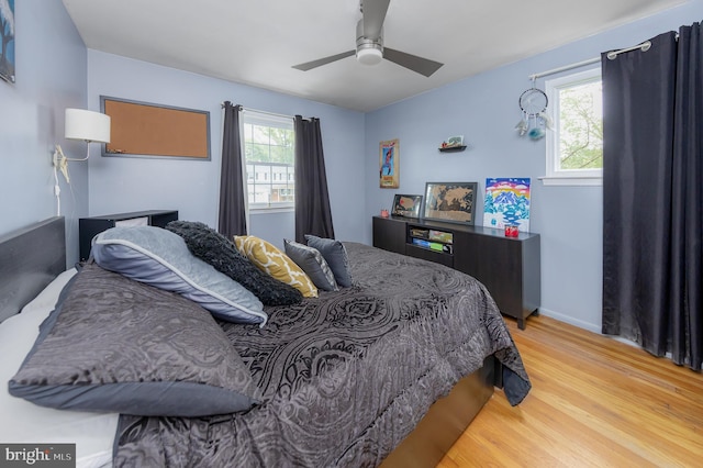 bedroom featuring light hardwood / wood-style floors, multiple windows, and ceiling fan