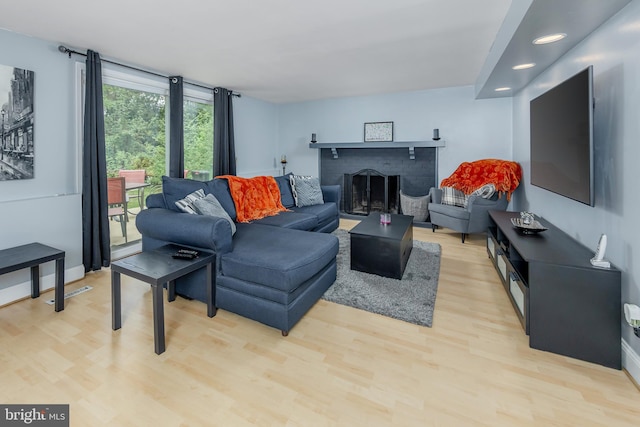 living room with light hardwood / wood-style floors and a fireplace