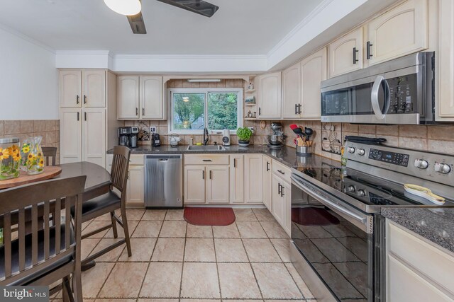 kitchen featuring appliances with stainless steel finishes, light tile patterned flooring, tasteful backsplash, and sink