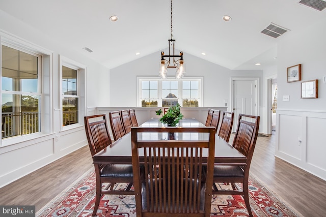 dining area featuring hardwood / wood-style flooring and vaulted ceiling