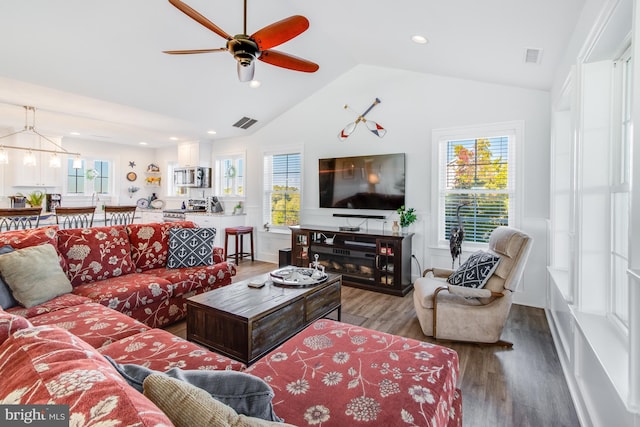 living room with lofted ceiling, plenty of natural light, ceiling fan with notable chandelier, and hardwood / wood-style floors