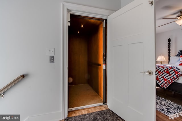 hallway featuring wood-type flooring and elevator