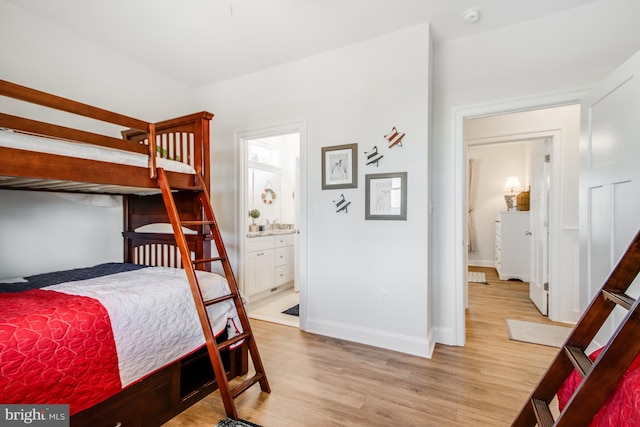 bedroom with ensuite bathroom and light wood-type flooring