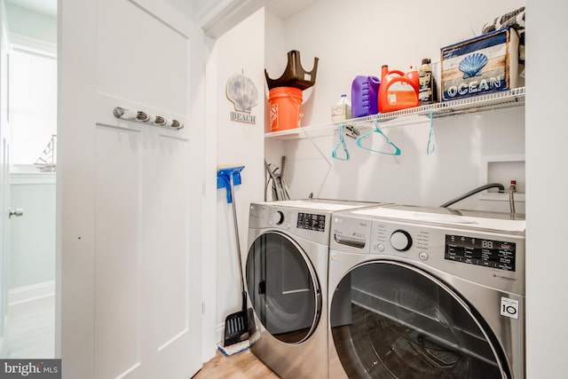 laundry area with wood-type flooring and separate washer and dryer