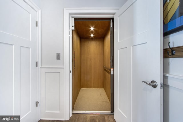 interior details with wood-type flooring and elevator