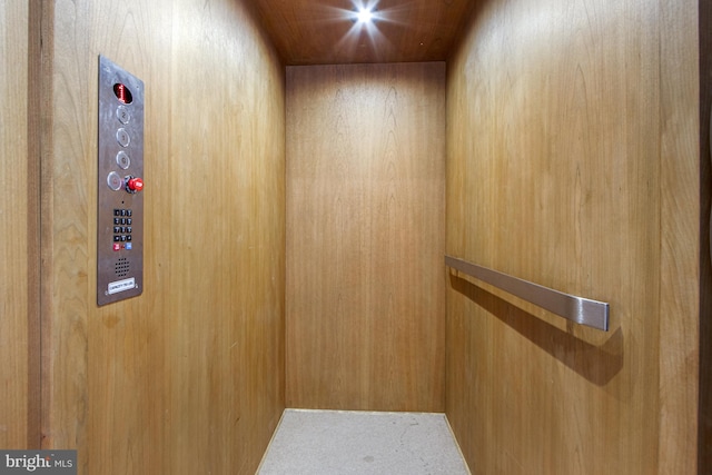 room details featuring wood walls and elevator