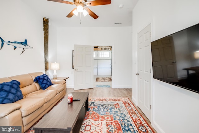 living room with light hardwood / wood-style flooring and ceiling fan