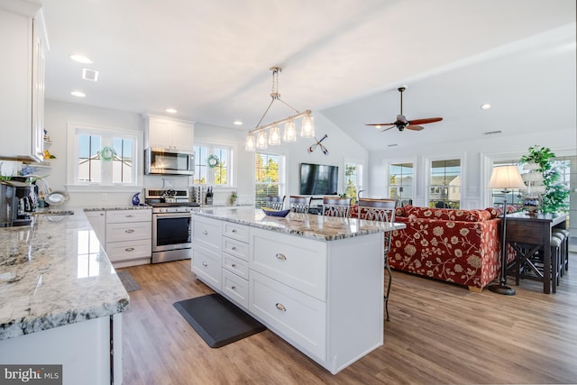 kitchen with white cabinetry, a healthy amount of sunlight, appliances with stainless steel finishes, and a center island