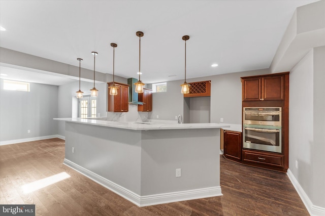 20069 Forest Farm Ln, Ashburn, VA 20147 - kitchen featuring a peninsula, stainless steel double oven, hanging light fixtures, and dark wood-type flooring