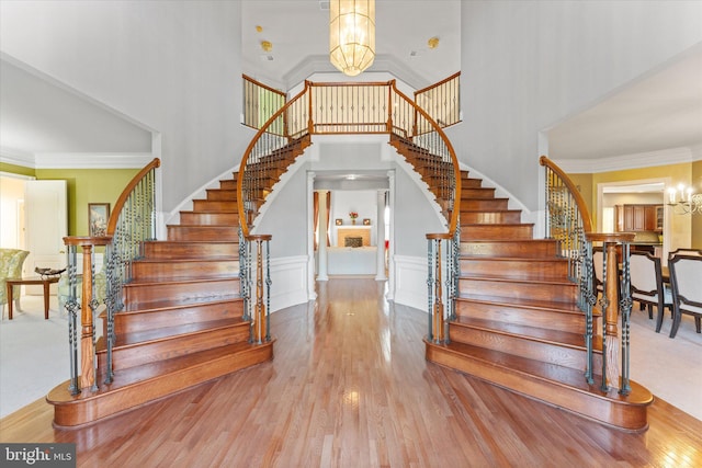 20069 Forest Farm Ln, Ashburn, VA 20147 - staircase with an inviting chandelier, ornamental molding, a high ceiling, and wood finished floors