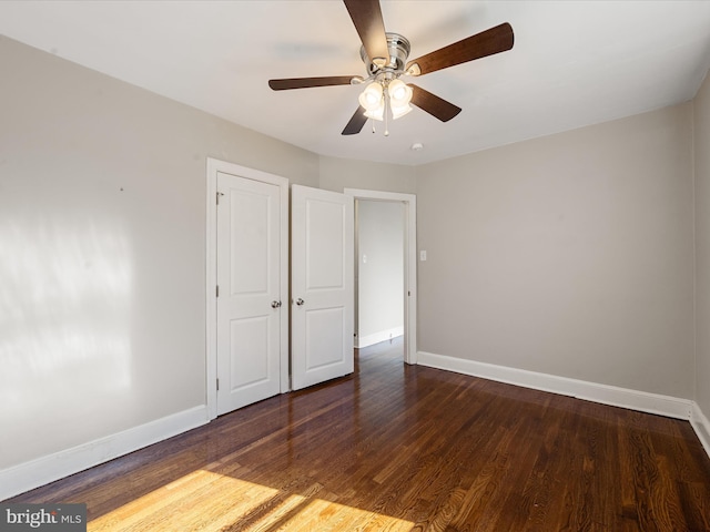 unfurnished bedroom featuring dark hardwood / wood-style flooring, a closet, and ceiling fan