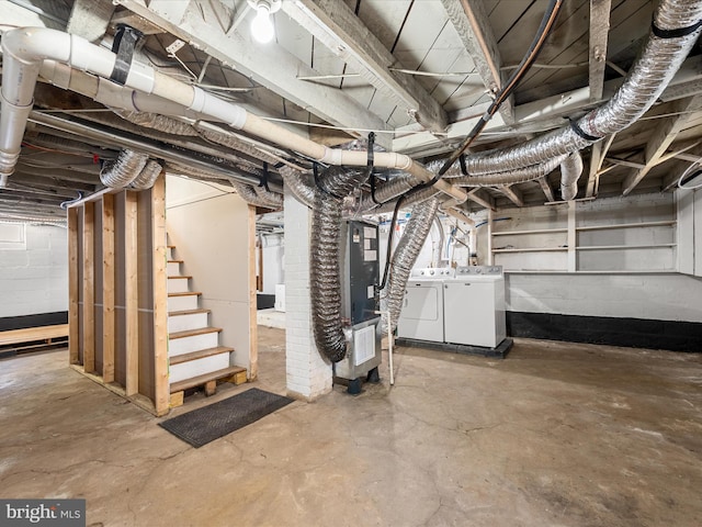 basement with washing machine and clothes dryer and heating unit