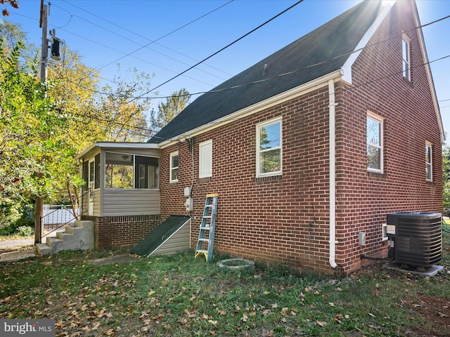 view of side of property featuring central air condition unit and a sunroom