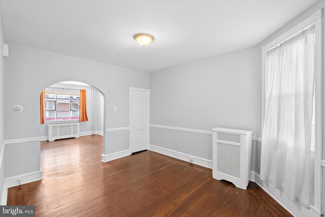 empty room featuring dark hardwood / wood-style floors and radiator