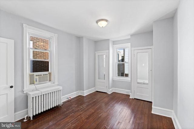 spare room with dark hardwood / wood-style flooring and radiator