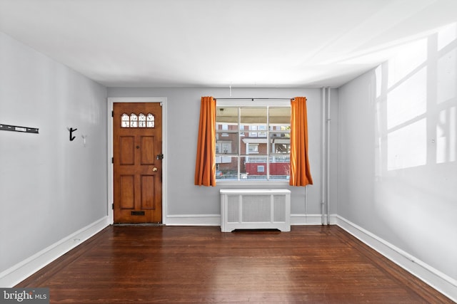 entrance foyer with dark hardwood / wood-style flooring and radiator