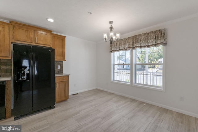1362 Connecticut Ave, Hagerstown, MD 21740 - kitchen with black appliances, a chandelier, brown cabinets, decorative backsplash, and baseboards