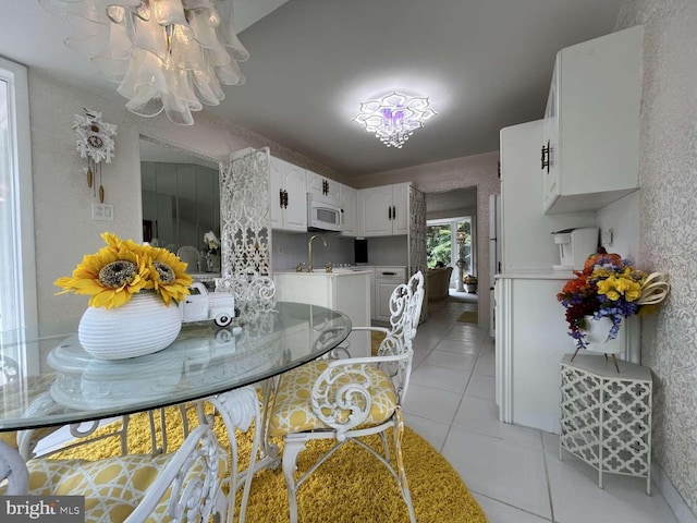 tiled dining area with sink and a notable chandelier