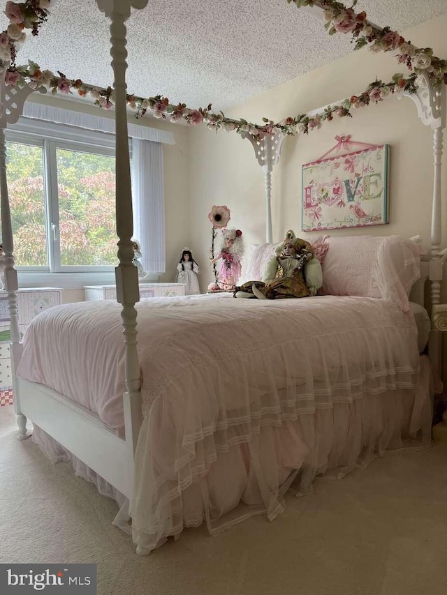 bedroom featuring a textured ceiling and carpet flooring