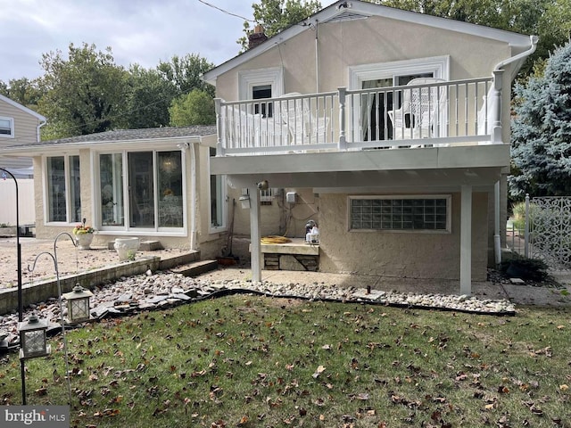 back of property with a patio area, a lawn, and a balcony