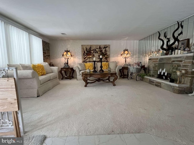 living room featuring carpet and a stone fireplace