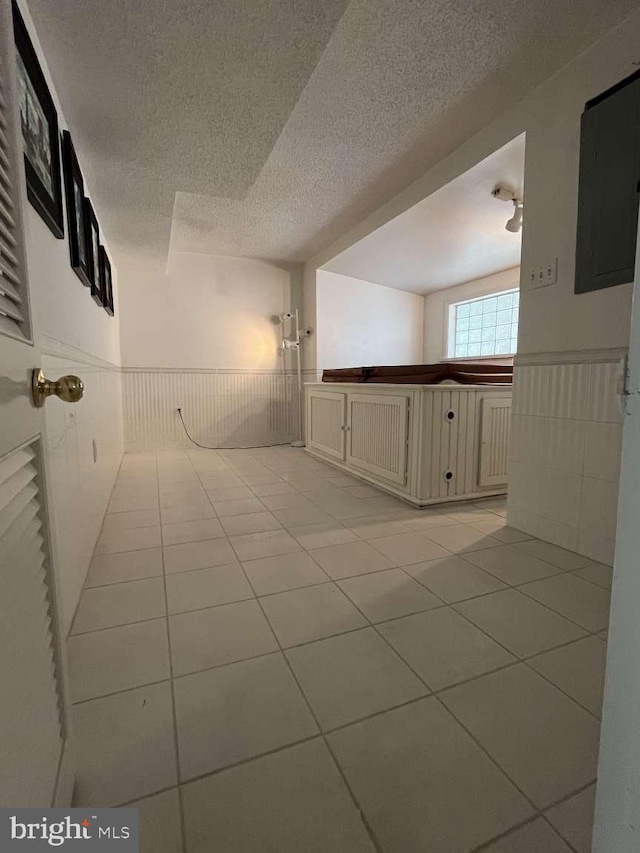 tiled empty room featuring a textured ceiling