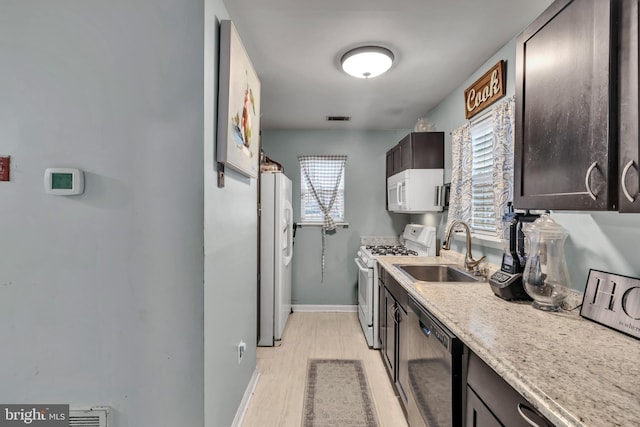 kitchen with dark brown cabinets, light hardwood / wood-style floors, sink, and appliances with stainless steel finishes