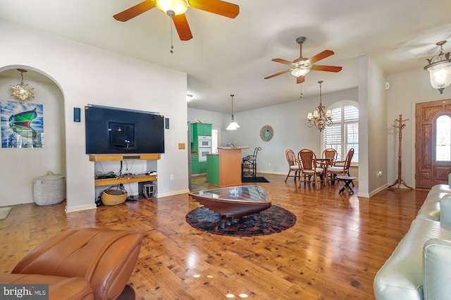 living room with wood-type flooring and ceiling fan with notable chandelier