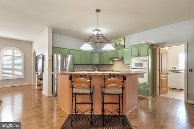 kitchen featuring a breakfast bar, light hardwood / wood-style flooring, and an island with sink