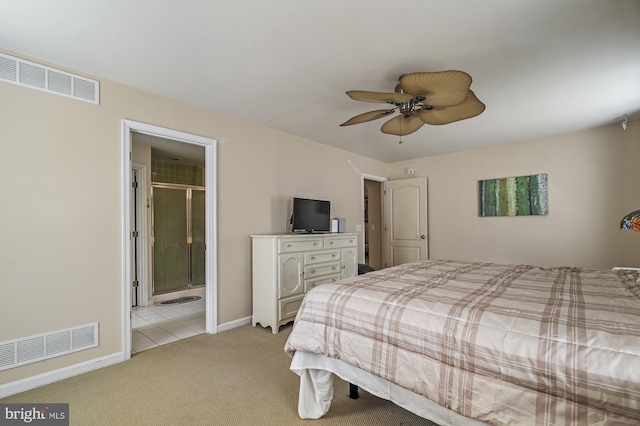 bedroom featuring ceiling fan, ensuite bathroom, and light colored carpet