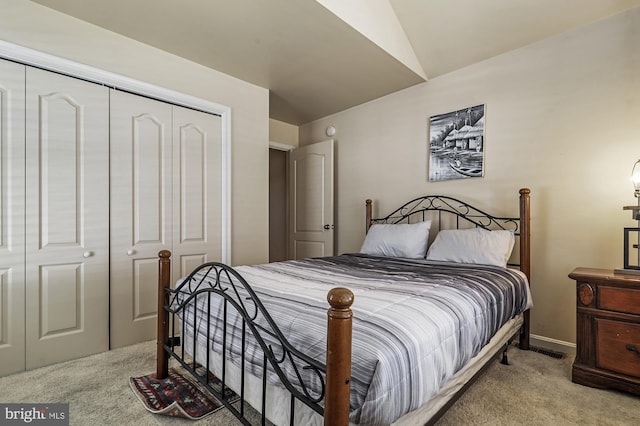 carpeted bedroom featuring lofted ceiling and a closet