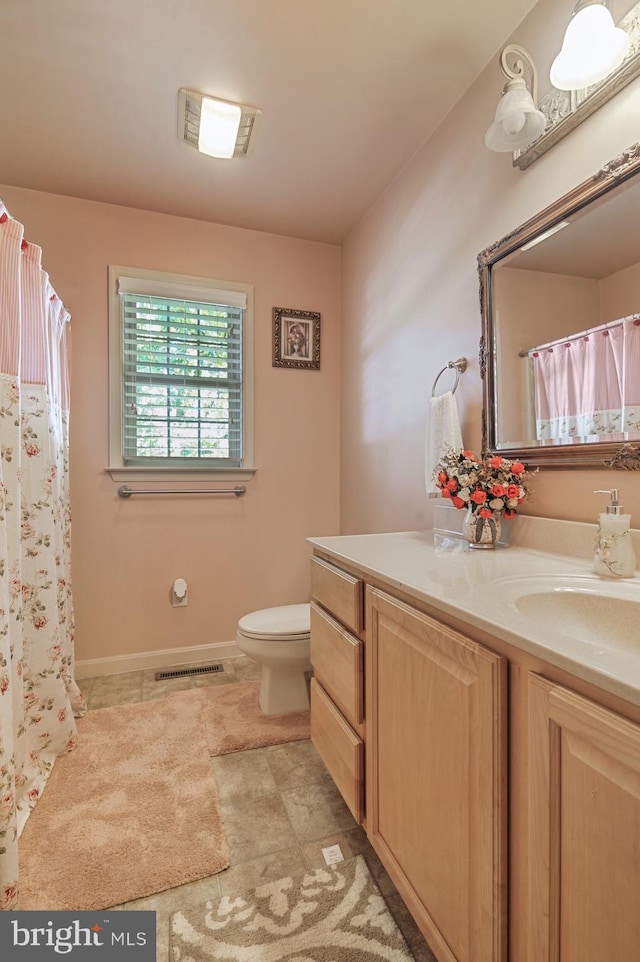 bathroom with vanity, toilet, and tile patterned flooring