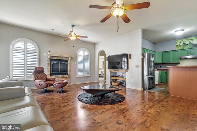 living room featuring dark hardwood / wood-style floors, ceiling fan, and a wealth of natural light