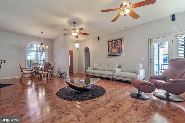 living room with hardwood / wood-style floors and ceiling fan with notable chandelier