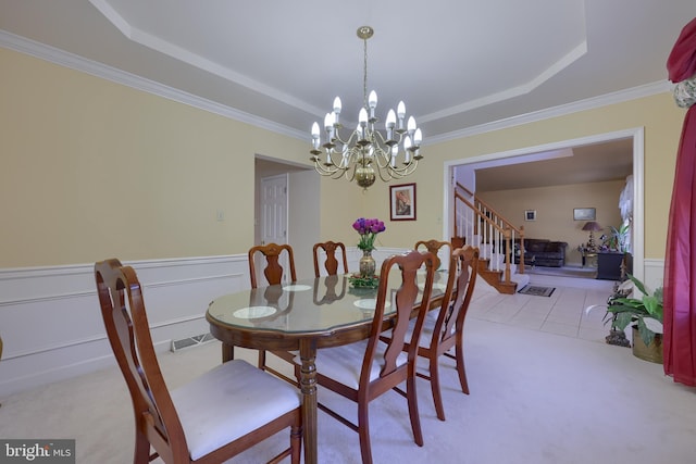 dining area with a notable chandelier, ornamental molding, light colored carpet, and a raised ceiling