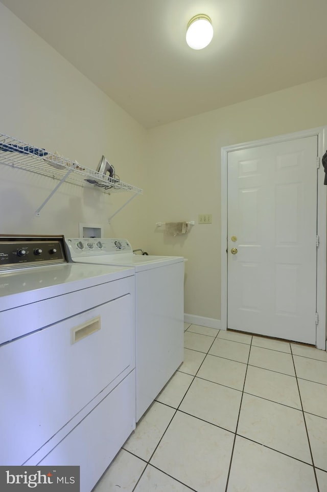 laundry room with washing machine and dryer and light tile patterned floors