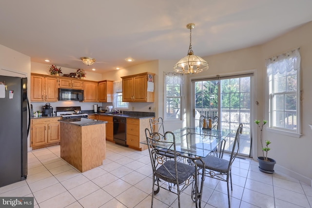 kitchen featuring black appliances, a center island, an inviting chandelier, and light tile patterned floors