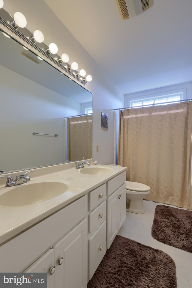 bathroom featuring vanity, toilet, tile patterned floors, and walk in shower