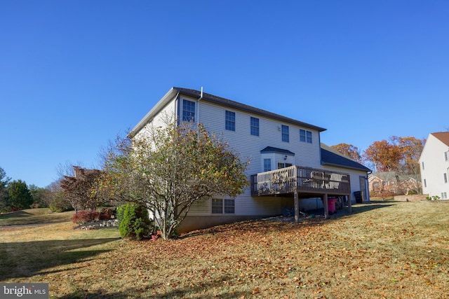 rear view of property with a yard and a wooden deck