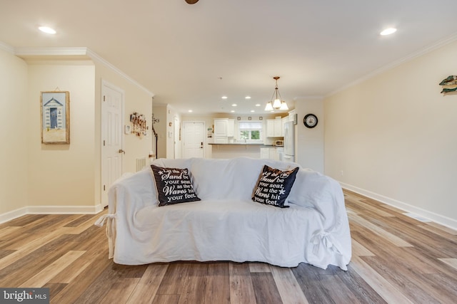 living room featuring crown molding, a notable chandelier, and light hardwood / wood-style flooring