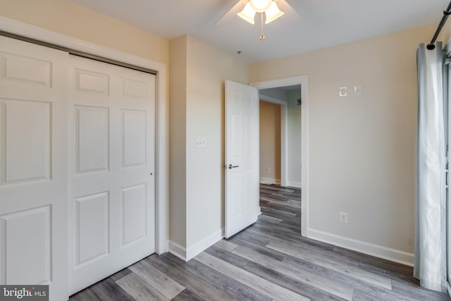 unfurnished bedroom featuring a closet, ceiling fan, and hardwood / wood-style flooring