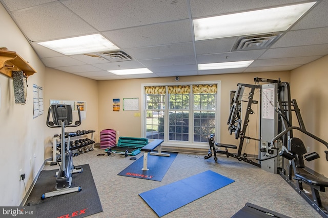 exercise area with carpet floors and a paneled ceiling