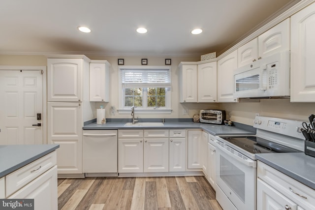 kitchen with white cabinetry, sink, and white appliances