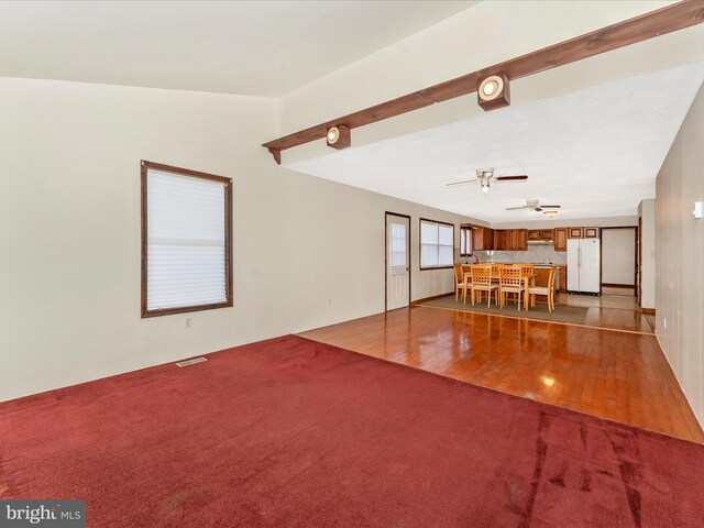 unfurnished living room featuring wood-type flooring and ceiling fan