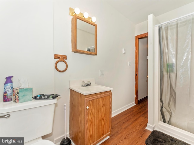 bathroom with toilet, hardwood / wood-style flooring, a shower with curtain, and vanity